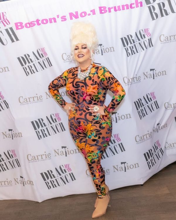 Abby Cummings posing at the Drag Me To Brunch step-and-repeat at Carrie Nation in Boston