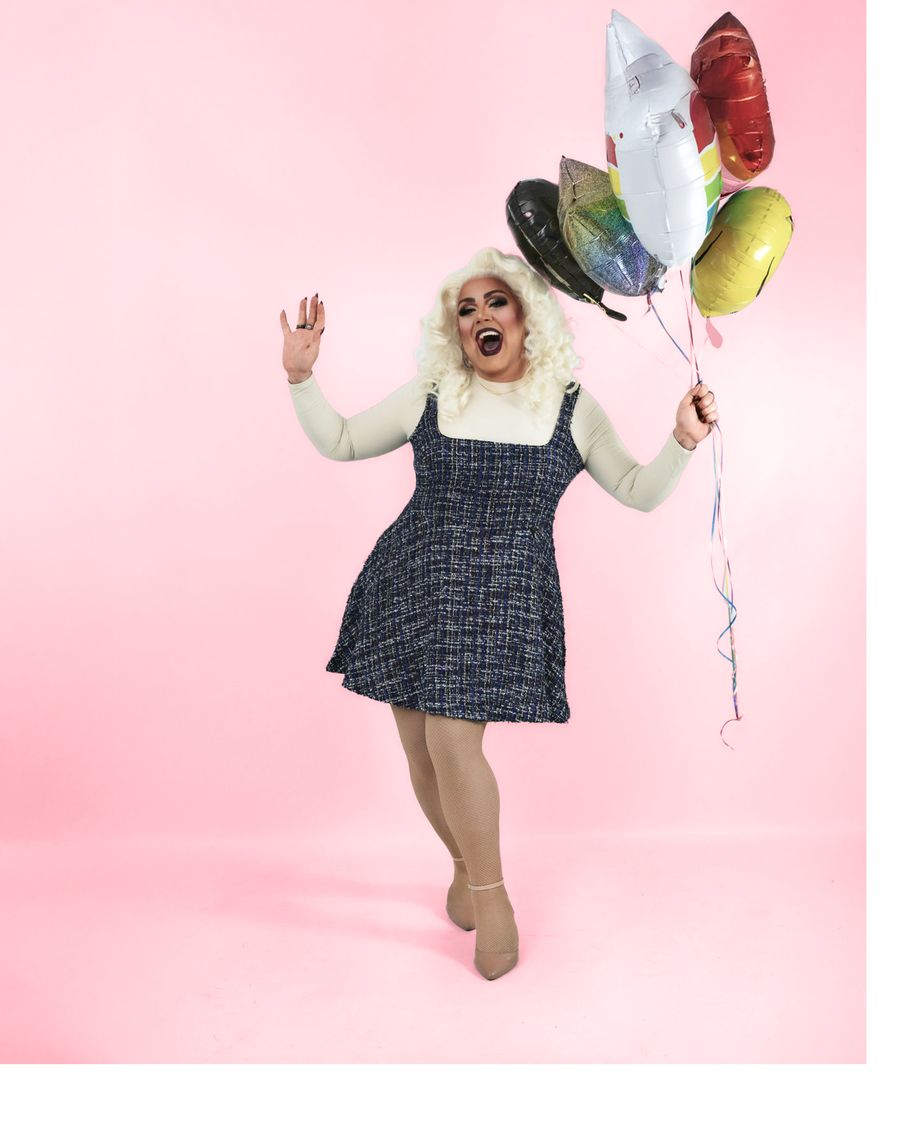 Abby Cummings mid-kick in a tweed dress, holding a bunch of balloons
