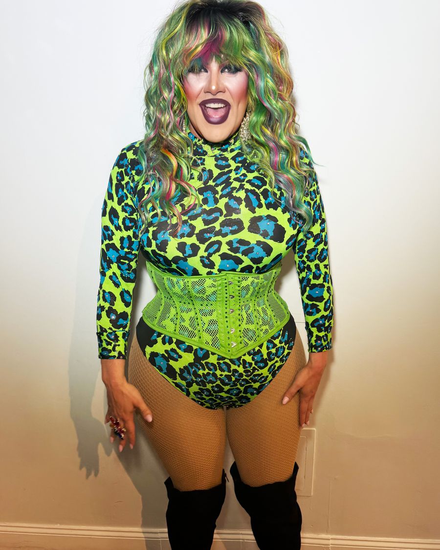 Abby Cummings in a neon green leopard bodysuit and corset with rainbow-streaked hair